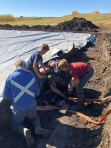 Grandchildren working with grandparents DNA gardens Alberta dugout.