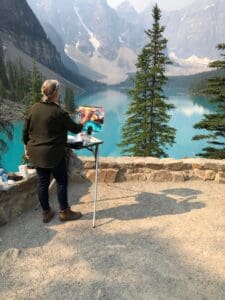 An artist painting a mountain landscape